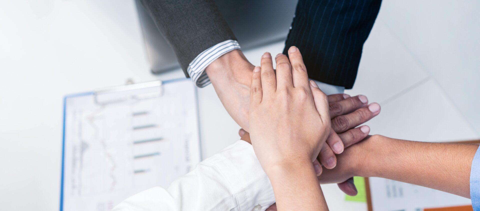 top-view-group-of-business-people-stack-hands-put-2021-12-09-12-52-13-utc